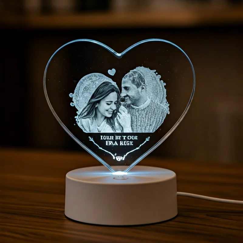 Ein herzförmiges personalisiertes Kristall mit dem Foto eines Paares und einer gravierten Nachricht, auf einem LED-Lichtsockel.